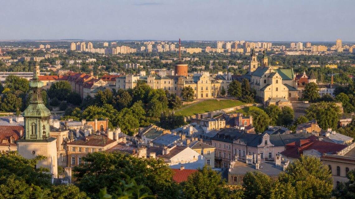 Panorama Lublina — Stare Miasto na wzgórzu i osiedla mieszkaniowe z zielenią w tle.