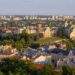 Panorama Lublina — Stare Miasto na wzgórzu i osiedla mieszkaniowe z zielenią w tle.